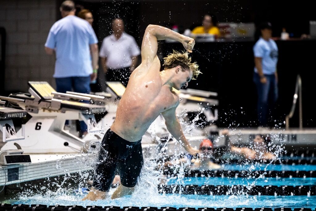 Nikolas mid-meet, fist raised, water exploding